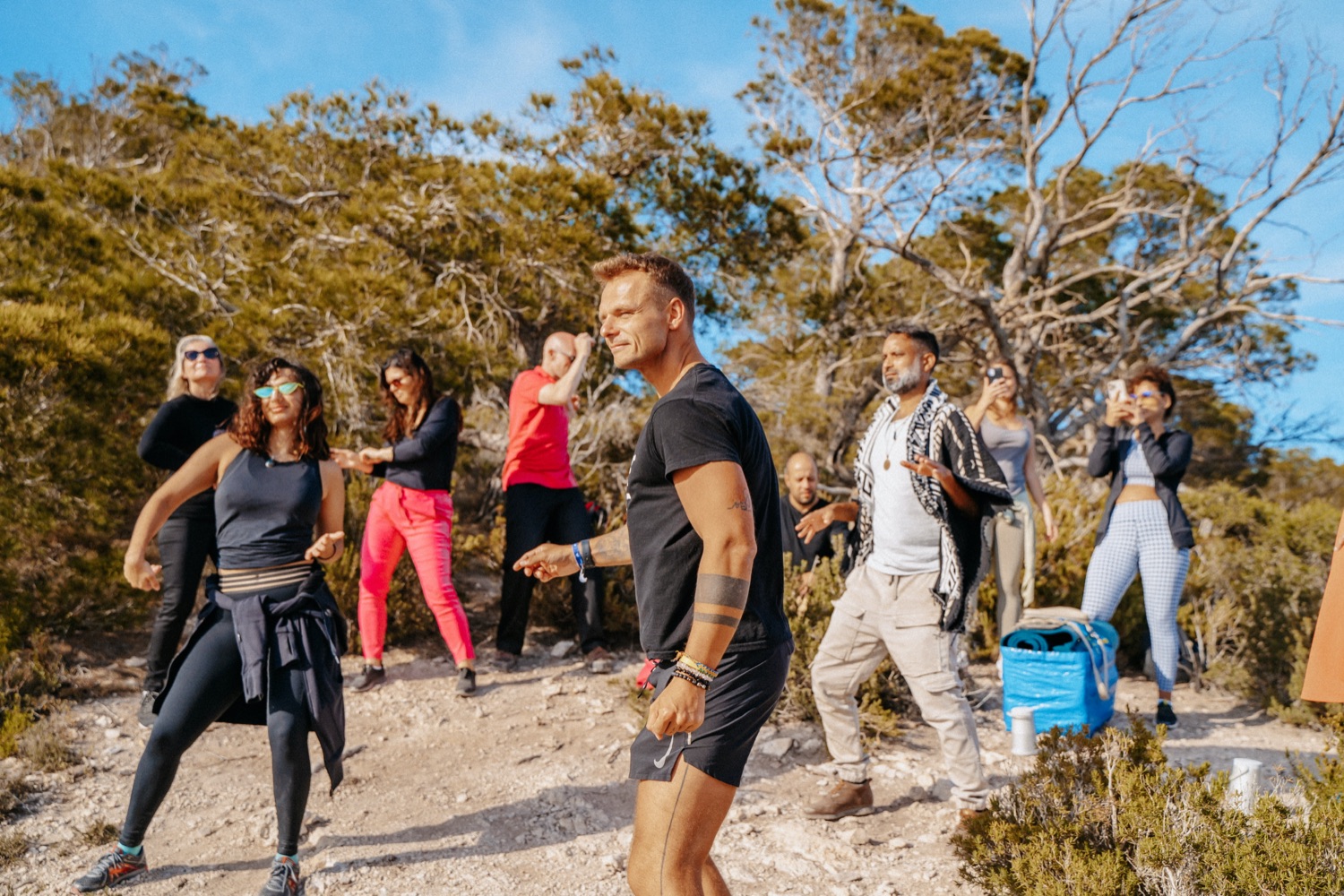 Piotr leading outdoor movement with a group on a coastal hillside