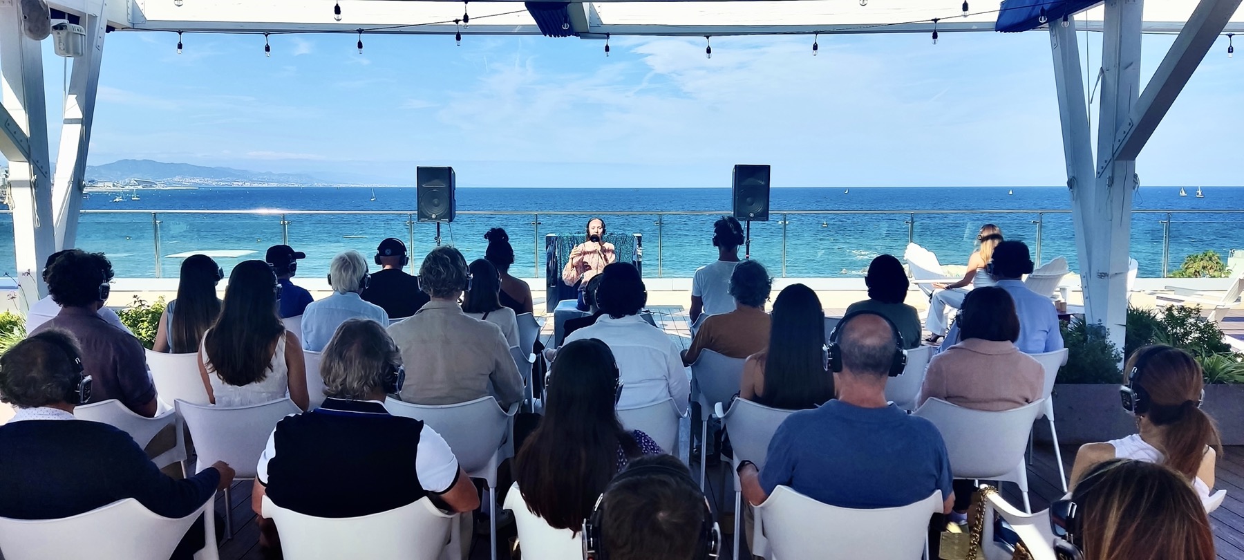Yulia guiding a seaside rooftop breathwork group with the Mediterranean behind